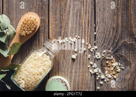 Pinsel, Meersalz, Seife und getrocknete Blumen auf Holzhintergrund. Stockfoto