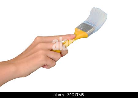 Die Hand einer Frau bemalt die Wand mit einem Pinsel in Weiß, isoliert auf weißem Hintergrund. Lifestyle-Reparaturen in der neuen Wohnung Stockfoto