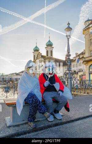 Luzern, Schweiz - 20. Februar 2023: Teilnehmer an Kostümen und Stadtdenkmälern im Hintergrund, Teil des Fasnacht-Karnevals, in Luzern (Lu Stockfoto