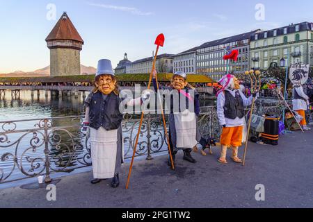 Luzern, Schweiz - 20. Februar 2023: Teilnehmer an Kostümen und Stadtdenkmälern im Hintergrund, Teil des Fasnacht-Karnevals, in Luzern (Lu Stockfoto