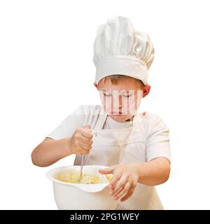 Ein Junge in weißer Koch-Kleidung kocht in einer Küche zu Hause, isoliert auf weißem Hintergrund Stockfoto
