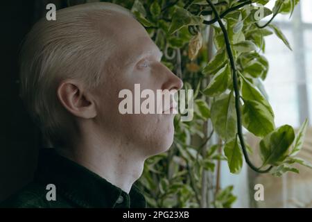 Ein Albino-Typ mit grünen Pflanzen auf dunklem Hintergrund Stockfoto