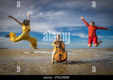 Tänzer und Cellisten treten am Strand von Cape Cod auf Stockfoto