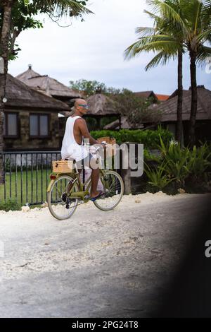 Ein Mann fährt mit dem Fahrrad zum Strand, Bali. Stockfoto