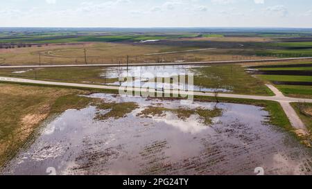 Minibus auf der Straße durch überflutete Landschaften im Frühling, aus der Vogelperspektive von der Drohne pov Stockfoto