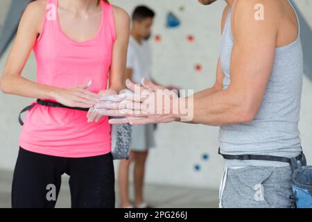 Kletterer, die Hände mit Magnesiumpulver beschichten Stockfoto