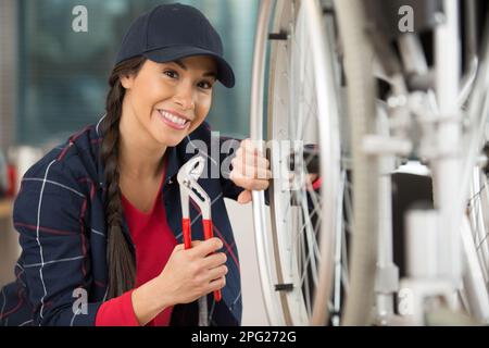 Mechanikerin, die einen Rollstuhl repariert Stockfoto