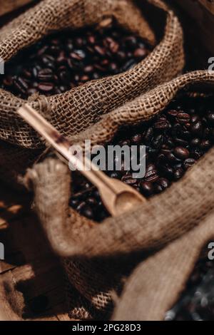 Geröstete Kaffeebohnen in Leinenholz. Rustikales Vintage-Konzept Stockfoto