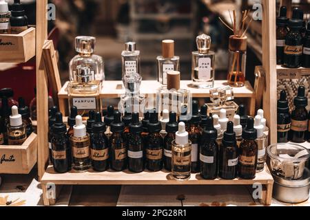 Schwarze Braunglasflaschen mit Pipetten. Geruch von ätherischem Duftöl. Prüfgerät Parfüm-Miniaturen auf einem Holzständer. Stockfoto