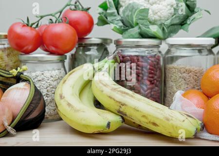 Zusammensetzung von Lebensmitteln in wiederverwendbaren Verpackungen, Netzbeuteln und Glasbechern. Das Konzept von Leben und Einkaufen ohne Verschwendung. Kein Plastik. Stockfoto