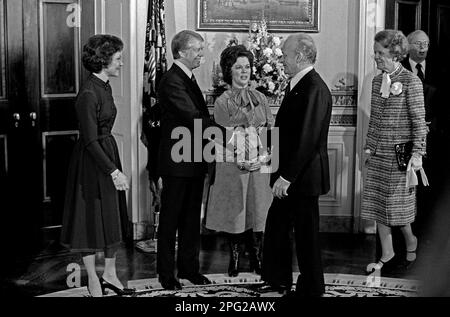 US-Präsident Jimmy Carter, links in der Mitte, begrüßt Botschafter Jacques Kosciusco-Morizet von Frankreich, rechts in der Mitte, im Blauen Raum des Weißen Hauses in Washington, DC, am ersten vollen Tag der Carter-Mondale-Administration am 21. Januar 1977. Im Zentrum steht der Protokollchef der US Shirley Temple Black. First Lady Rosalynn Carter steht links und Madame Morizet ist rechts. Kredit: Barry A. Soorenko/CNP Stockfoto