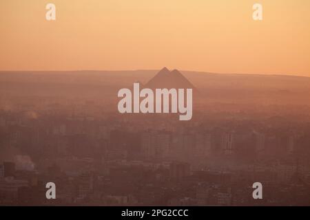 Ägypten, Kairo, die Pyramiden von Gizeh in der Ferne und Sonnenuntergang über Kairo mit Blick nach Osten vom Kairoer Turm. Stockfoto