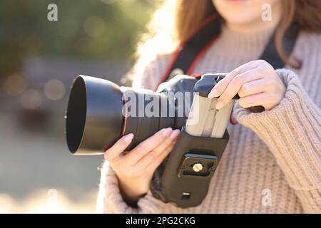 Nahaufnahme eines Fotografen, der im Winter den Akku der dslr-Kamera wechselt Stockfoto