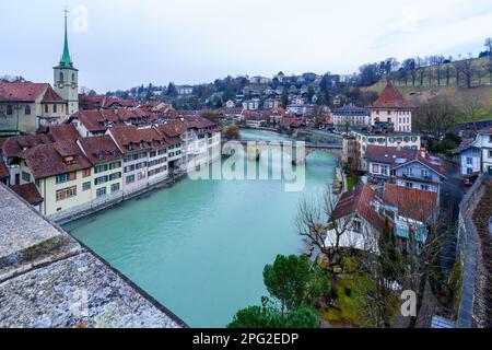 Blick auf den Fluss Aare, die Nydeggkirche, die Untertorbrücke mit verschiedenen Gebäuden, Einheimischen, Und Besucher in Bern, Schweiz Stockfoto