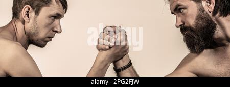 Arme ringen dünne Hand, großer starker Arm im Studio. Zwei Männerhände umklammten Arm Wrestling, stark und schwach, ungleiche Übereinstimmung Stockfoto