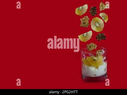 Joghurtdessert mit Kiwis und Müslischiffen, serviert in Glas. Schwebende Objekte, Kopierraum Stockfoto