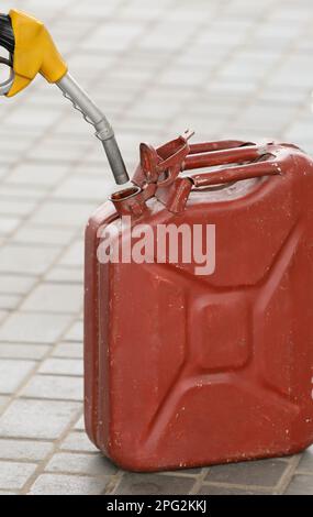 Ein Mann füllt kanister an einer Tankstelle. Ein Mann füllt an einer Tankstelle Benzin in einen Kanister. Ich gieße Benzin in einen Kanister. Stockfoto