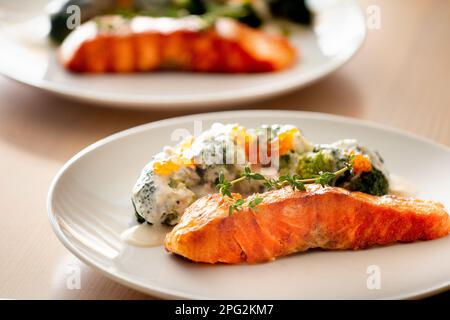 Lachssteak auf einem weißen Teller. Gegrillter Lachs mit Brokkoli. Lachs mit Gemüse. Richtige Ernährung. Stockfoto