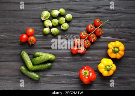 Tomaten, Gurken, Paprika, Rosenkohl auf einem hölzernen Hintergrund von oben. Mischung aus gesundem Gemüse. Rohes Sommergemüse. Stockfoto