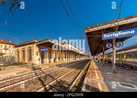 Savigliano, Cuneo, Italien - 20. März 2023: Trenitalia Bahnhof mit Gleisen und Bahnsteigen auf der Linie zwischen Turin und Savona mit blauem Himmel Stockfoto