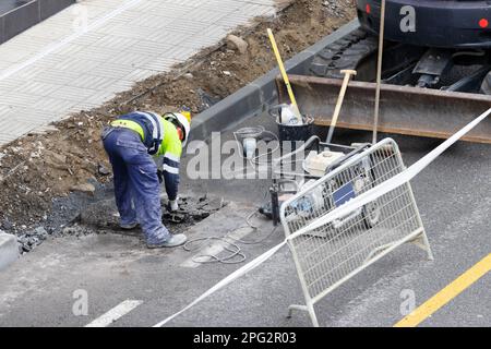 Bauarbeiter mit mehreren Maschinen, die an der Renovierung einer Straße in der Stadt arbeiten Stockfoto