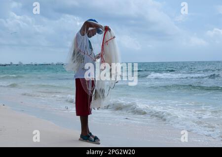 Angeln als Lebensart: Fischer, die ihr Netz am Strand auswerfen Stockfoto