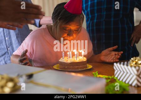 Glückliche Gruppe von verschiedenen älteren Freunden, die Geburtstag mit Kuchen und Geschenken feiern Stockfoto