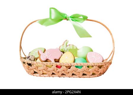 Farbenfrohe osterkekse im Korb mit mehrfarbigen Ostereiern, isoliert auf weißem Hintergrund. Pastellfarbene Ostereier. Urlaubskonzept. Stockfoto