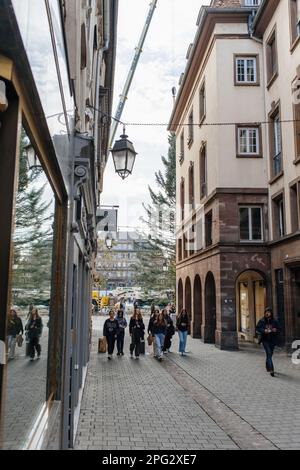 Straßburg, Frankreich - 28. Oktober 2022: Eine lebhafte Straße in Straßburg, Frankreich, ist voller junger Mädchen, die mit ihrer festlichen Dekoration und Architektur auf dem Weihnachtsmarkt spazieren. Stockfoto