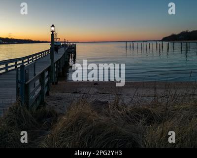 Ein Luftblick auf den Port Jefferson Harbor während eines wunderschönen und wolkenlosen Sonnenuntergangs im Winter Stockfoto