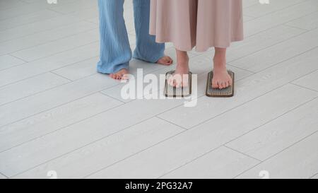 Weiße Frau steht auf Sadhu-Brettern mit Therapeuten-Unterstützung. Stockfoto