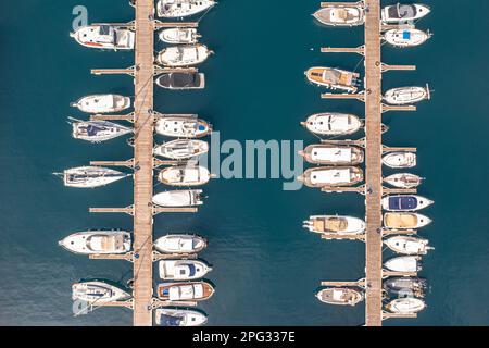 Yachten, Segel- und Motorboote in einem Hafen in Spanien. Uber das türkisblaue Wasser des Mediteranischen Meeres. Draufsicht von oben. Stockfoto
