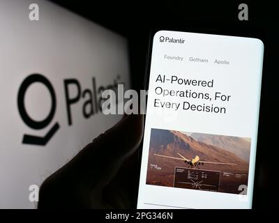 Person, die ein Mobiltelefon mit einer Website des US-Analyseunternehmens Palantir Technologies Inc. Auf dem Bildschirm mit Logo hält. Konzentrieren Sie sich auf die Mitte des Telefondisplays. Stockfoto