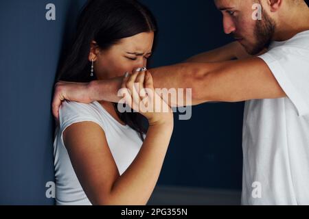 Gewalttätiger, aggressiver junger Mann schlägt seine Freundin zu Hause Stockfoto