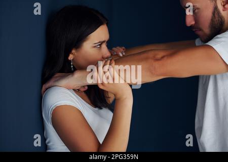 Gewalttätiger, aggressiver junger Mann schlägt seine Freundin zu Hause Stockfoto