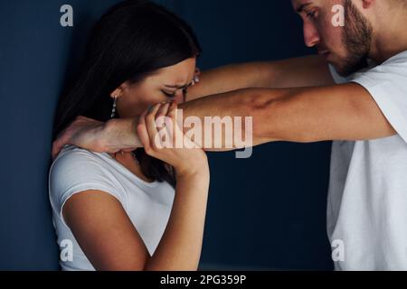 Gewalttätiger, aggressiver junger Mann schlägt seine Freundin zu Hause Stockfoto