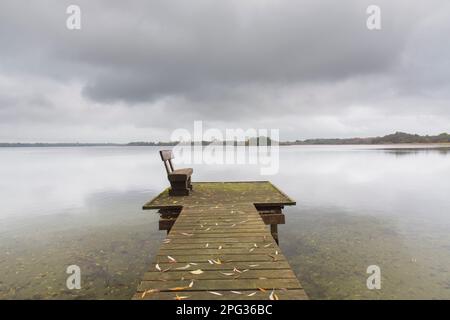 Landungsbrücke und Bank am Schaalsee im Herbst. Schleswig-Holstein, Deutschland Stockfoto