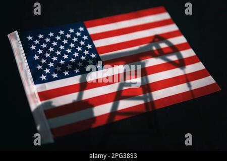 Die Ölindustrie der USA. Bohrinseln im Hintergrund der Flagge der Vereinigten Staaten von Amerika. Bergbau und Ölexport. Handel auf dem globalen Kraftstoffmarkt. Kraftstoff i Stockfoto