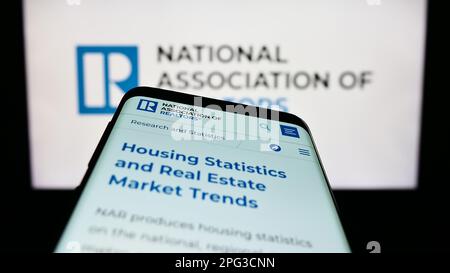 Mobiltelefon mit Webseite der US National Association of Realtors (NAR) auf dem Bildschirm vor dem Firmenlogo. Fokus auf oberer linker Seite des Telefondisplays. Stockfoto