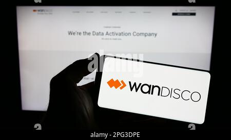 Person, die ein Smartphone mit dem Logo des Softwareunternehmens WANdisco plc auf dem Bildschirm vor der Website hält. Konzentrieren Sie sich auf das Display des Telefons. Stockfoto