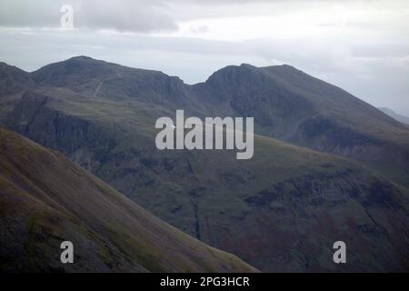 Low Flying Military Turboprop Cargo Flugzeug vorbei an der Scafell Mountain Range von Pillar im Lake District National Park, Cumbria, England, Großbritannien. Stockfoto