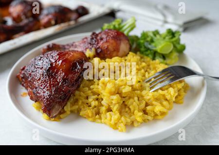 PILAU-Reis mit glasiertem Huhn und Brokkoli auf einem Teller Stockfoto
