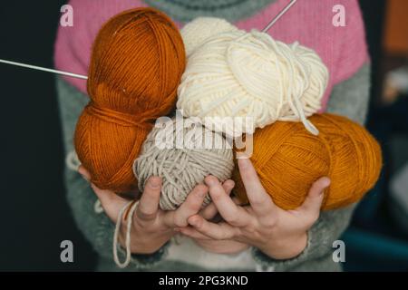 Frauenhände mit farbigen Garnbällen zum Stricken. Auswahl an farbenfroher Garnwolle. Das Konzept von Stricken, Wolle kaufen, handgemacht, Hobby Stockfoto