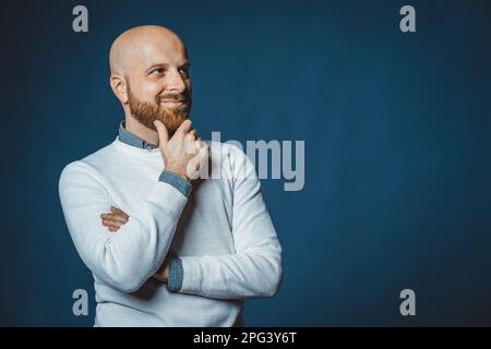 Foto eines weißen netten Typen mit Bart und blauem Hintergrund Stockfoto