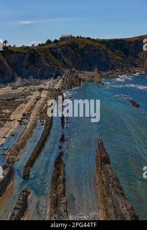 Gebrochene Küste in Liencres Cantabria, an einem sonnigen Sommertag bei Ebbe. Leerer Strand, Ebbe, klarer Himmel, Luftaufnahme Stockfoto