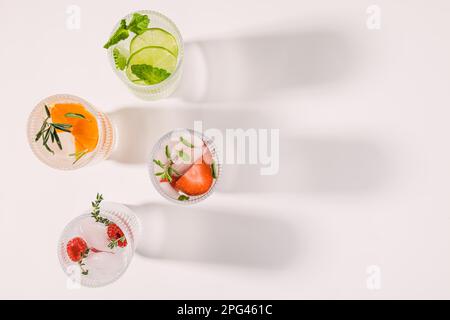 Wasser mit verschiedenen Geschmacksrichtungen, sommerliche Erfrischungsgetränke in gerippten Gläsern, Draufsicht Stockfoto