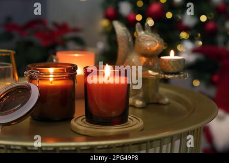 Brennende Kerzen auf dem Tisch im zu Weihnachten dekorierten Zimmer Stockfoto