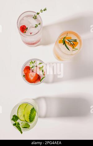 Limonaden mit verschiedenen Geschmacksrichtungen auf dem weißen Tisch, sommerliche Erfrischungsgetränke, Draufsicht Stockfoto