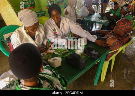 Medizinisches Personal betreut die Frau während einer kostenlosen medizinischen Untersuchung anlässlich des Internationalen Frauentags in der Mobolaji Johnson Arena in Lagos, Nigeria. Stockfoto