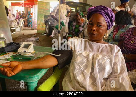 Medizinisches Personal betreut die Frau während einer kostenlosen medizinischen Untersuchung anlässlich des Internationalen Frauentags in der Mobolaji Johnson Arena in Lagos, Nigeria. Stockfoto